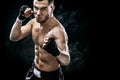 Sportsman muay thai boxer fighting in boxing cage. Isolated on black background with smoke. Copy Space. Royalty Free Stock Photo