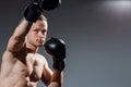 Sportsman muay thai boxer fighting in boxing cage. Sport concept.