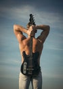 Sportsman with muscular back hold electric guitar