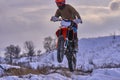 Sportsman racer man fulfills a fast ride on a motorcycle on the road extreme. The race track is very uneven. Photo as the racer p