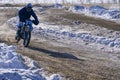 Sportsman racer man fulfills a fast ride on a motorcycle on the road extreme. The race track is very uneven. Sunny frosty winter d