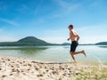 Sportsman running in water of lake in summer resort Royalty Free Stock Photo