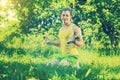 Sportsman sitting on grass and lifting weights in park field ins Royalty Free Stock Photo