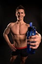 Sportsman with sport bottle on dark background Royalty Free Stock Photo