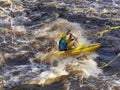 Sportsman on a sports kayak rowing on a raging river.