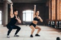 Sportsman and sportswoman doing squats with kettlebell in the sport center Royalty Free Stock Photo