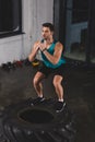 sportsman squating on lifting tire Royalty Free Stock Photo