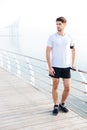 Sportsman standing on pier near the sea Royalty Free Stock Photo