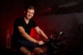 Portrait of cheerful sportsman on stationary maching bike in health club Royalty Free Stock Photo