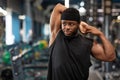 Sportsman stretching his muscles before workout training at gym