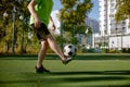 Sportsman tapping on his ankle while training at city football court