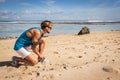 sportsman tying shoelaces on sneakers on beach Royalty Free Stock Photo