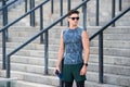 Sportsman wearing sunglasses and wearable device technology watch while exercising. Muscular athlete exercising outside