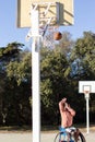 Sportsman in wheelchair throwing basketball into hoop Royalty Free Stock Photo