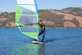 Professional windsurfer standing on board and holding sail. Space for copy Royalty Free Stock Photo