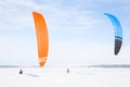 Sportsmen are snowkiting. Young men are skiing with kites on fresh snow in northern winter