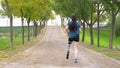 Sportsperson with prosthetic leg running along a park