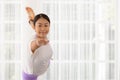 In sportswear, an Asian lady works out. Natarajasana, Lord of the Dance Pose, is being prepared. Asana for balancing and back