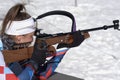 Sportswoman biathlete aiming, rifle shooting prone position. Biathlete Petrova Victoria Saint Petersburg in shooting range. Junior