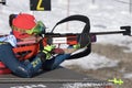 Sportswoman biathlete aiming, rifle shooting, reloading prone position. Kazakhstan biathlete Polina Yegorova in shooting range.