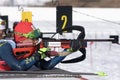 Sportswoman biathlete aiming, rifle shooting, reloading prone position. Biathlete Polina Yegorova Kazakhstan in shooting range.