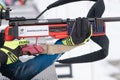 Sportswoman biathlete rifle shooting in prone position. Selective focus, extreme close-up shot. Biathlete in shooting