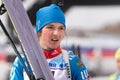 Sportswoman biathlete Soenko Violetta with skis in hands and rifle behind her after skiing and rifle shooting. Open