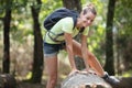 sportswoman cross tree trunk in forest