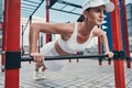 Sportswoman doing push-ups from a horizontal bar