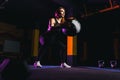Sportswoman doing squat exercises with fitness ball. Female exercising and stretching with medicine ball at gym Royalty Free Stock Photo