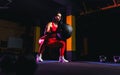 Sportswoman doing squat exercises with fitness ball. Female exercising and stretching with medicine ball at gym Royalty Free Stock Photo