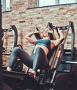 Sportswoman doing squatting in training machine