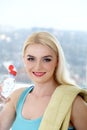 Sportswoman drinks water from a plastic bottle.