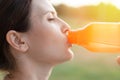 The sportswoman drinks water after training. Portrait of a young woman athlete who drinks from a bottle