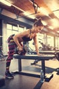 Sportswoman in gym exercise muscles and listen music