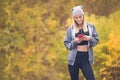 Sportswoman holding and looking at smartphone against yellow lea Royalty Free Stock Photo