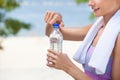 A sportswoman holds a bottle of water in her hand