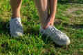 Sportswoman outdoors on grass touching painful twisted ankle. Athlete runner training accident