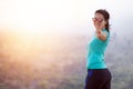 Sportswoman reaches a mountain top and raises arms celebrating the achievement and success of her physical activity purpose Royalty Free Stock Photo