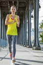 Sportswoman running on Pont de Bir-Hakeim bridge in Paris