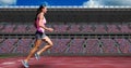 Sportswoman running on tracks against buildings