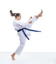 Sportswoman is training a kick in karategi