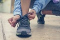 Sportswoman tying her shoelaces before the training. Close up.