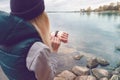 Sportswoman uses an electronic bracelet-pedometer standing on the lake shore. Travel and healthy lifestyle concept. Back