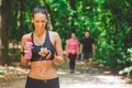 Sportswoman using smartphone app and walking on running track in the park. Royalty Free Stock Photo