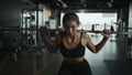 Sportwoman exercising with barbell in fitness class. Workout woman in gym with barbell