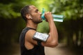 Sporty african american man drinking water, exercising outdoors Royalty Free Stock Photo