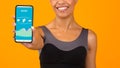 Sporty African American woman showing mobile phone with fitness tracker app on yellow background, closeup Royalty Free Stock Photo