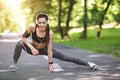 Sporty Asian Woman In Headphones Warming Up Before Jogging In Park Royalty Free Stock Photo