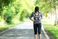 Sporty asian woman runner running and jogging through the road.  Outdoor Workout in a Park. Royalty Free Stock Photo